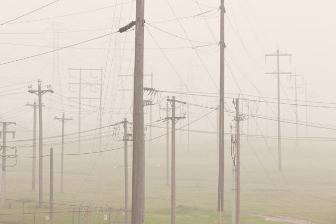 A forest of transmission towers and poles holding up a tangle of high voltage power lines near the Strathcona Refineries in Edmonton, Alberta are shrouded by the dense smoke from forest fires in BC in the late summer of 2010.